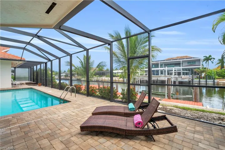 View of pool with a boat dock, a lanai, a patio area, and a water view