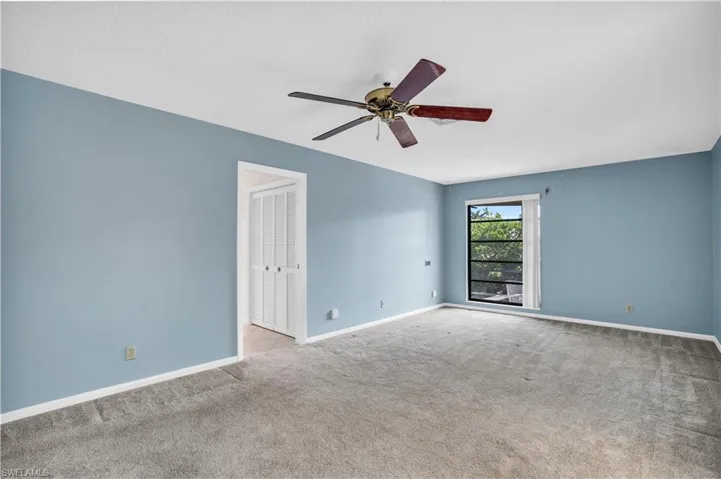 Carpeted spare room featuring ceiling fan