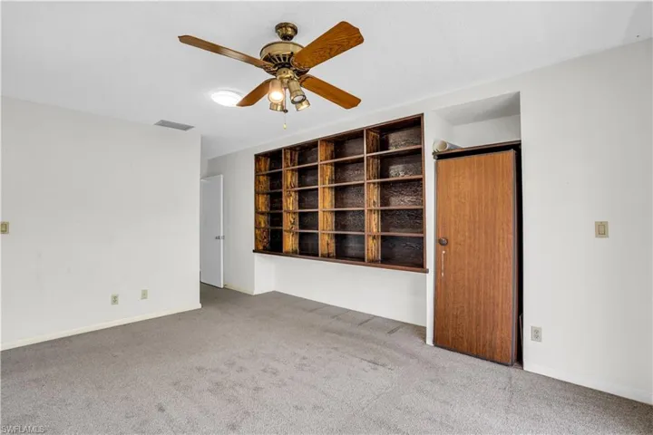 Carpeted spare room featuring ceiling fan