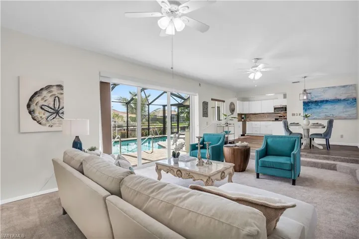 Carpeted living room with ceiling fan