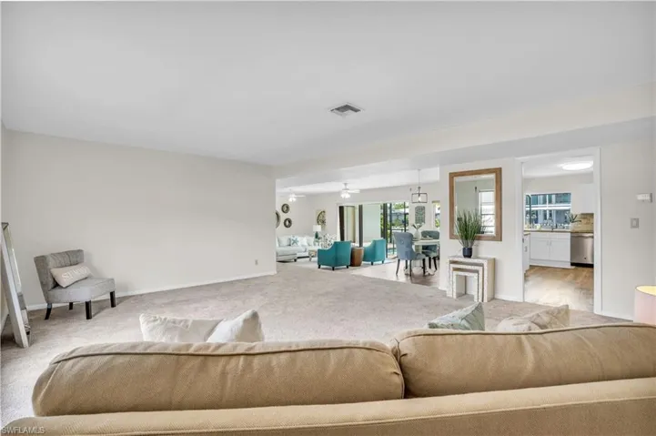 Carpeted living room featuring ceiling fan