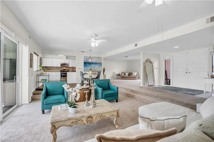 Living room with light carpet and ceiling fan