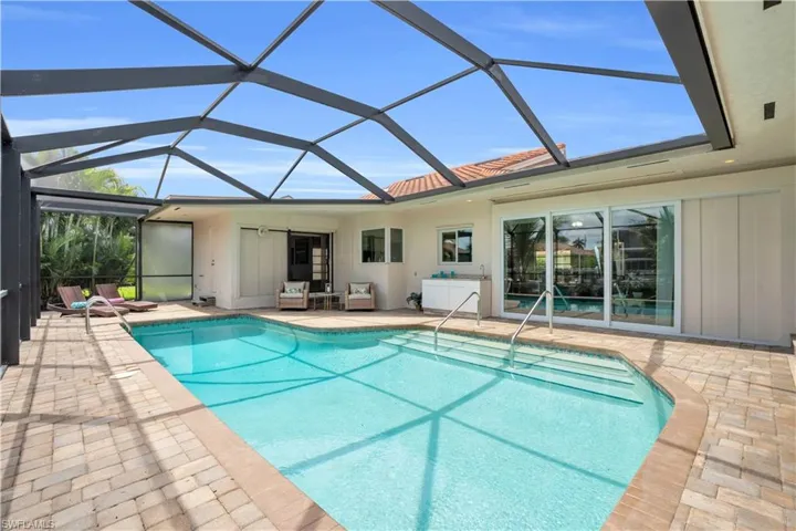 View of swimming pool with a patio, a lanai, and ceiling fan