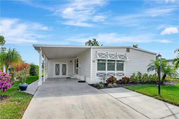 Manufactured / mobile home with a carport and a front lawn
