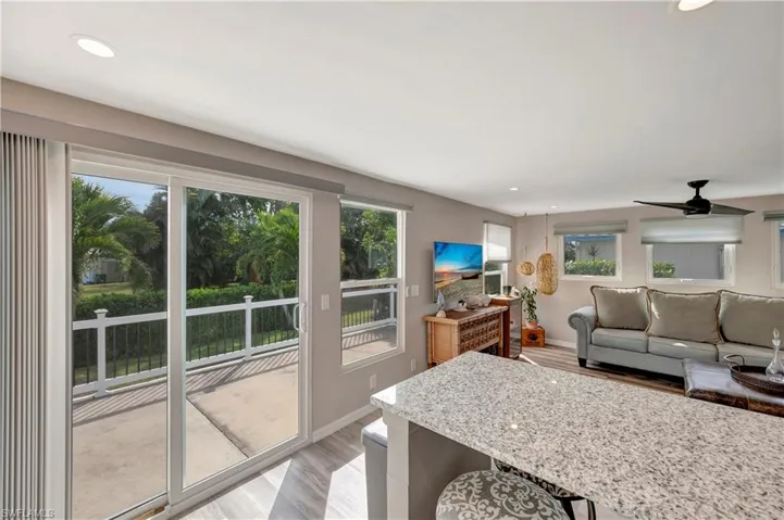 Living room featuring a wealth of natural light, ceiling fan, and light hardwood / wood-style flooring