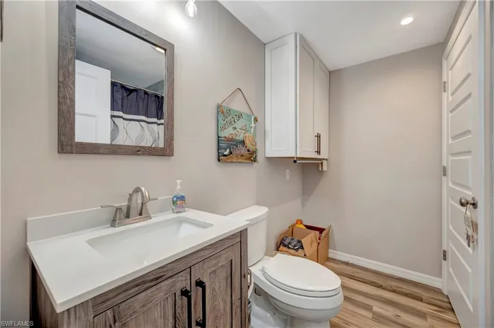 Bathroom featuring vanity, hardwood / wood-style flooring, and toilet