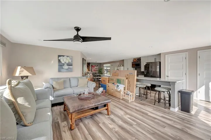 Living room with light hardwood / wood-style flooring and ceiling fan