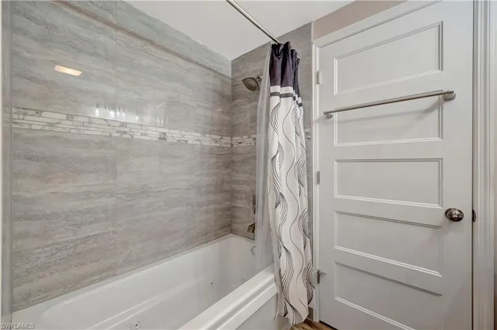 Bathroom with shower / bathtub jacuzzi combination with curtain