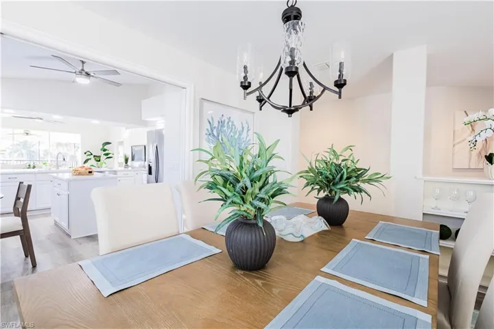 Dining space featuring light wood-style floors, a chandelier, and a ceiling fan