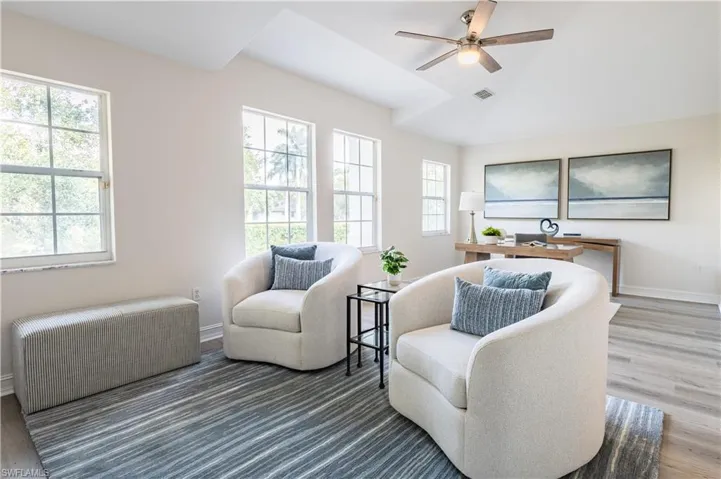 Sitting room featuring a ceiling fan, light wood finished floors, and vaulted ceiling