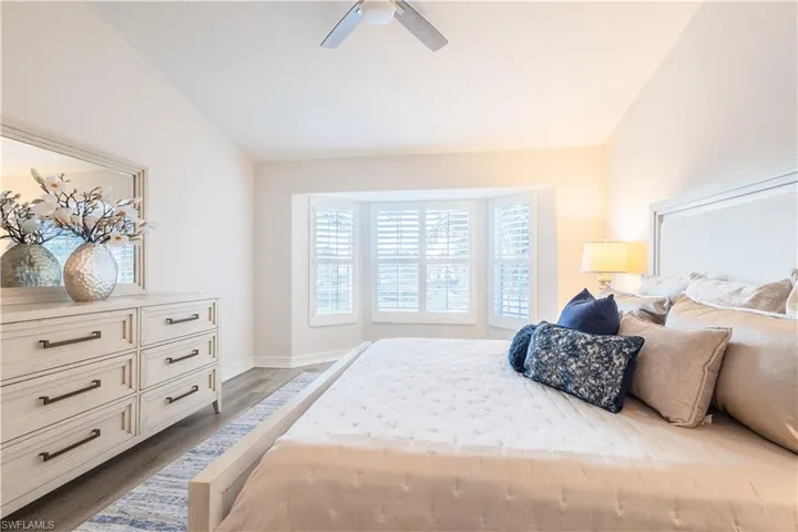 Bedroom featuring wood finished floors, a ceiling fan, and lofted ceiling