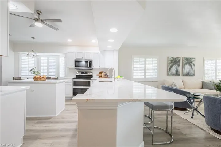 Kitchen with a center island, a peninsula, light wood-type flooring, stainless steel appliances, and open floor plan