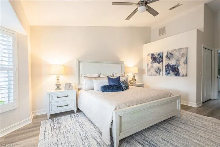 Bedroom featuring light wood-style floors, ceiling fan, and lofted ceiling