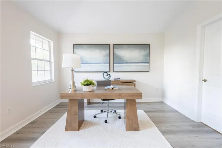 Office area featuring light wood-style flooring and baseboards
