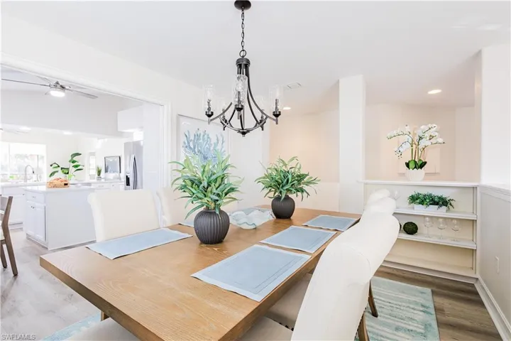 Dining space featuring light wood finished floors, a ceiling fan, and suspended lighting
