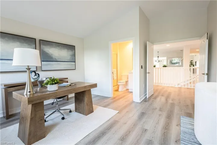 Office area with light wood-style floors, a chandelier, and lofted ceiling