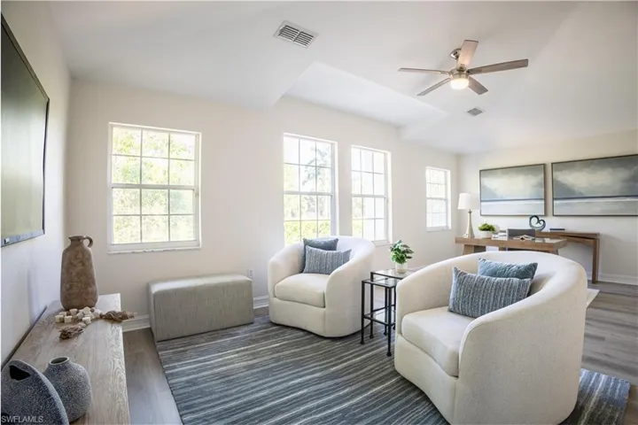 Living room featuring a ceiling fan, wood finished floors, and vaulted ceiling