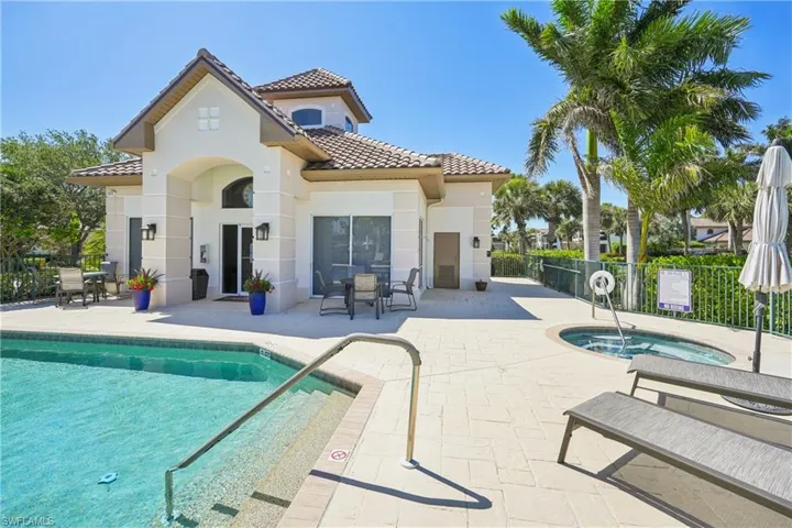 Back of house with outdoor dining space, a hot tub, a patio, and a tiled roof