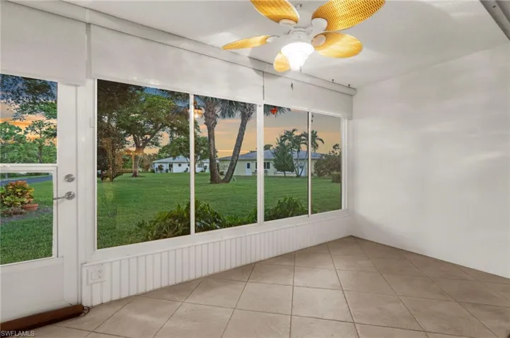 Unfurnished sunroom featuring a ceiling fan