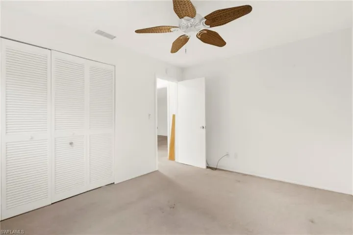 Unfurnished bedroom featuring carpet flooring, a ceiling fan, and a closet