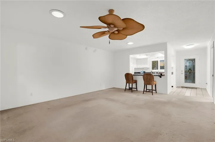 Living room featuring light colored carpet, recessed lighting, and a ceiling fan