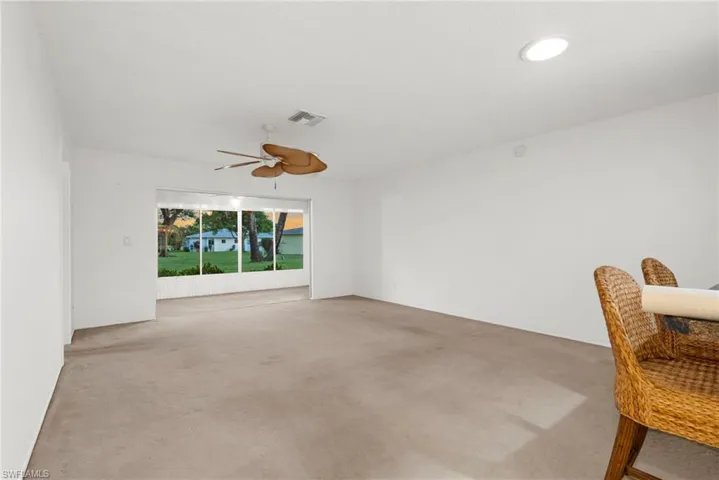 Carpeted empty room with ceiling fan