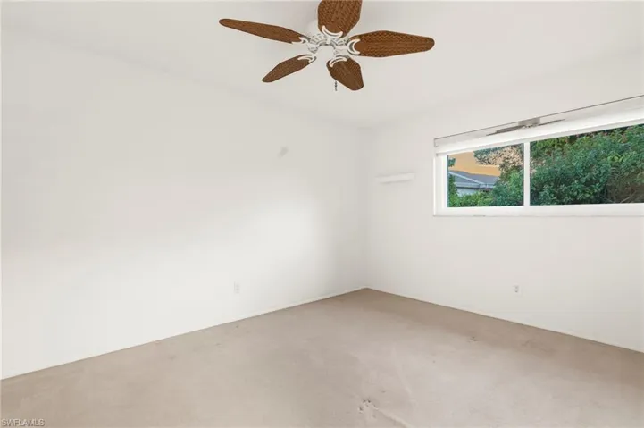 Spare room featuring carpet floors and a ceiling fan