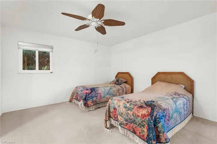 Carpeted bedroom featuring a ceiling fan and a textured ceiling