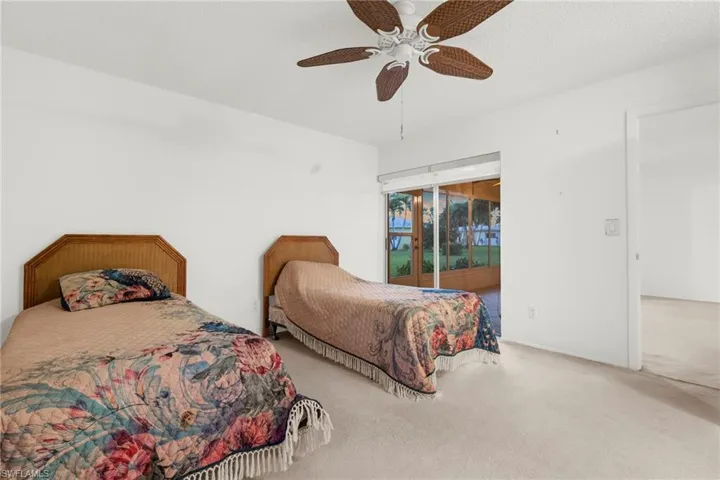 Carpeted bedroom with access to outside, ceiling fan, and a textured ceiling