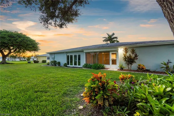 Back of property featuring stucco siding and a yard
