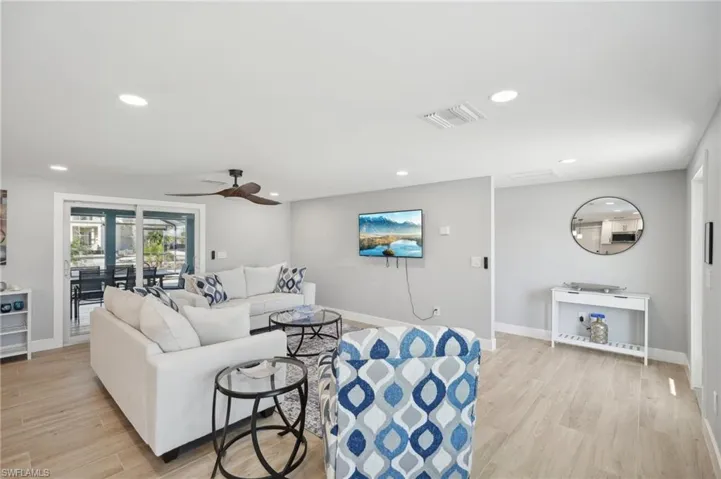 Living room with light wood-type flooring, ceiling fan, and recessed lighting