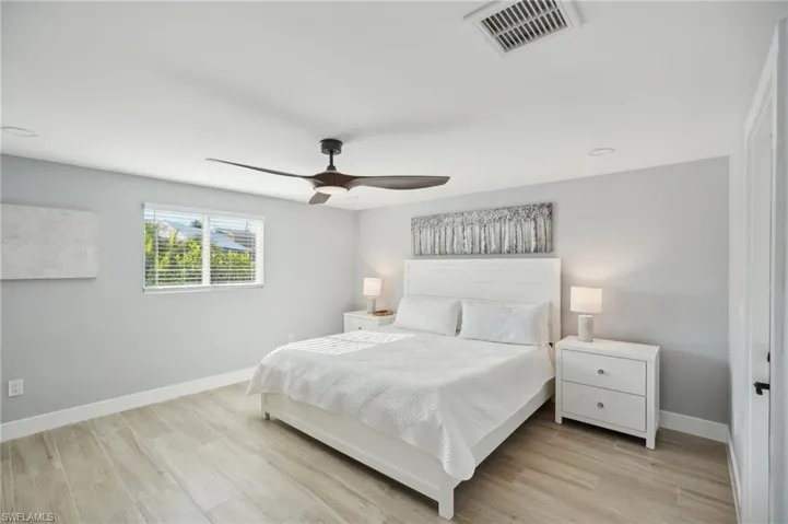 Bedroom with light wood-style floors, a ceiling fan, and recessed lighting