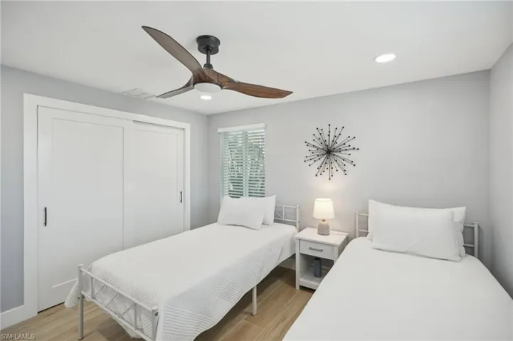 Bedroom with light wood-style floors, a closet, a ceiling fan, and recessed lighting