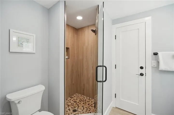 Bathroom featuring a stall shower, elevator, and recessed lighting