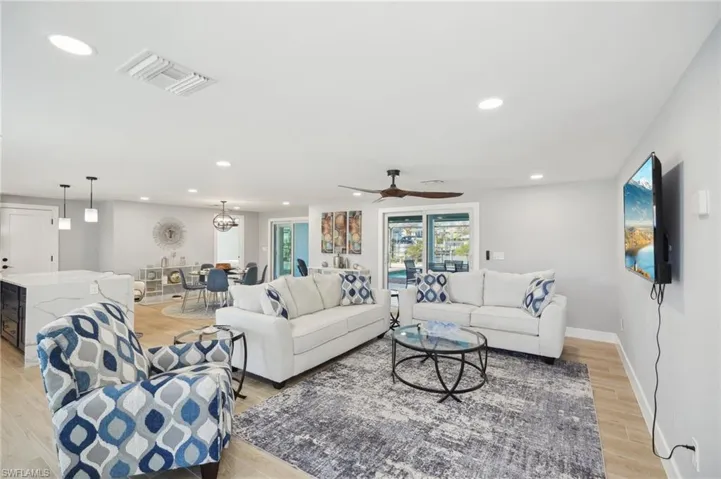Living room with recessed lighting, light wood-type flooring, and a ceiling fan