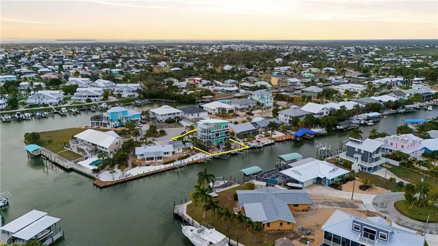 Aerial view at dusk of a residential view and a water view- virtually enhanced