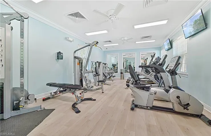 Exercise room featuring ceiling fan, ornamental molding, and light hardwood / wood-style floors