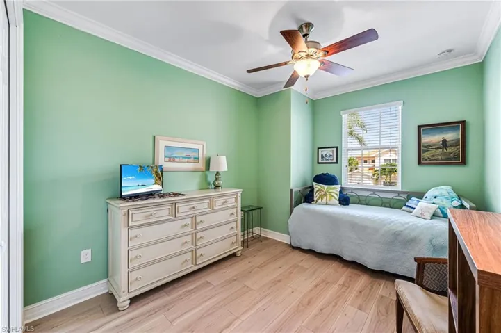 Guest Bedroom with ceiling fan, light wood-type flooring, and crown molding