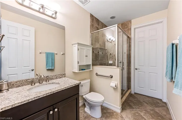 Master Bathroom with tile flooring, walk in shower, vanity, and toilet