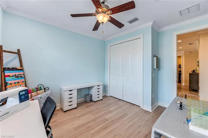 Guest Bedroom featuring crown molding, a closet, light hardwood / wood-style floors, and ceiling fan