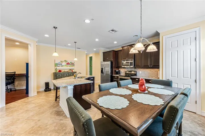 Tiled dining area featuring sink and ornamental molding