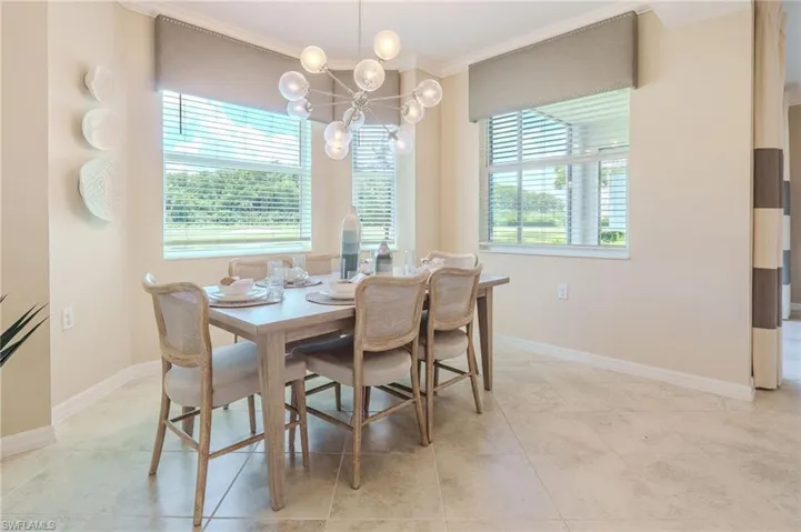 Neutral-toned wall paint, large windows, crown molding, and tiled flooring