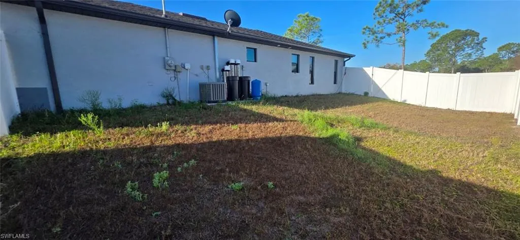 Back of property with stucco siding and a fenced backyard