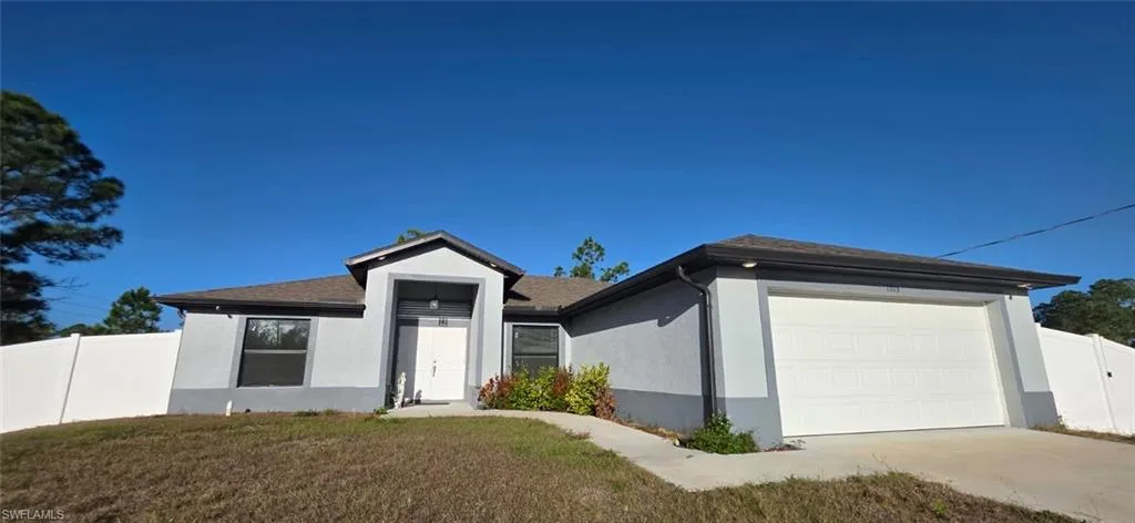 Ranch-style house featuring stucco siding, a garage, driveway, and roof with shingles