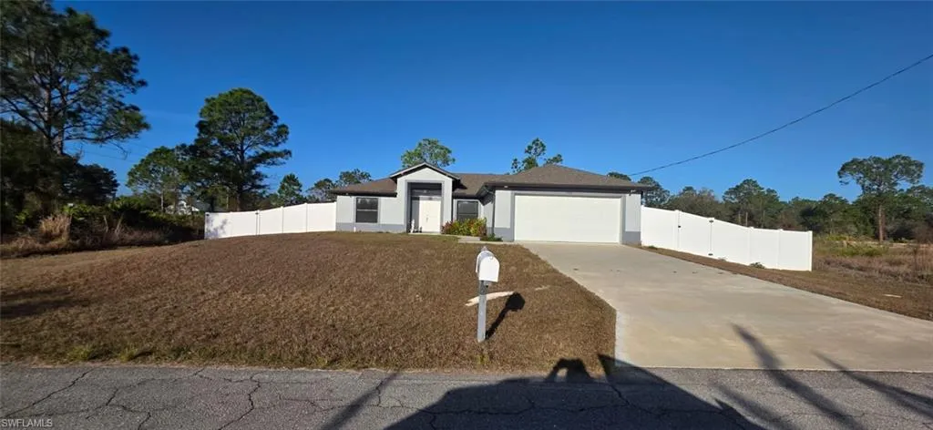Single story home with driveway, an attached garage, and stucco siding