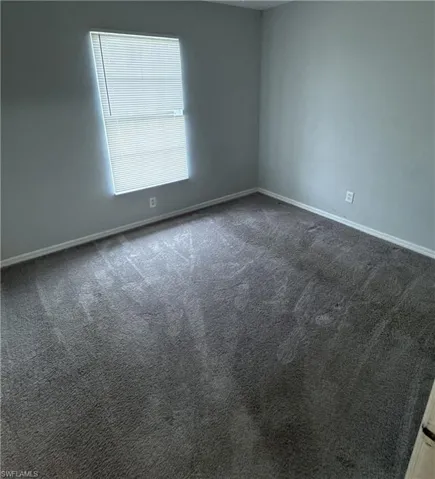 Unfurnished room with carpet flooring and baseboards