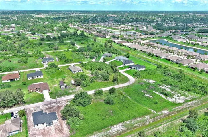Aerial view of property and surrounding area with nearby suburban area and a large body of water