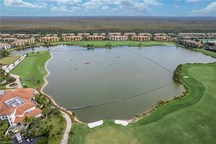 Drone / aerial view of a nearby body of water and a golf course