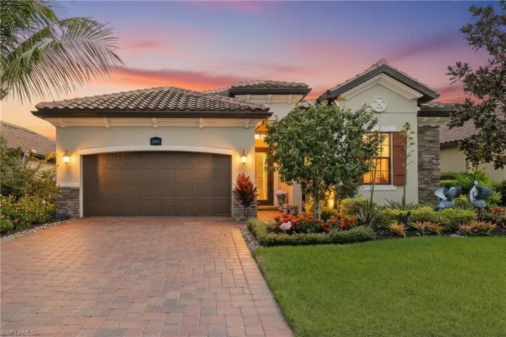 Mediterranean / spanish house featuring stone siding, decorative driveway, a tile roof, an attached garage, and stucco siding