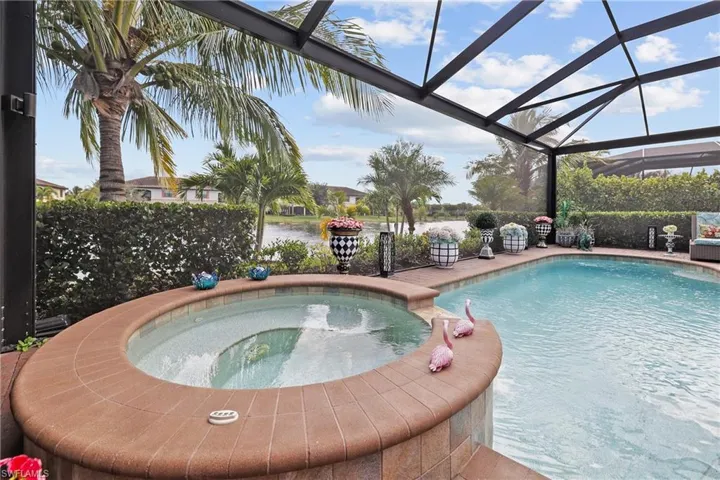 View of swimming pool with a pool with connected hot tub, a lanai, a sunroom, and a patio
